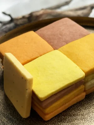 A mosaic of handcrafted citrus cookies showing a natural gradient of warm, sunset tones.
