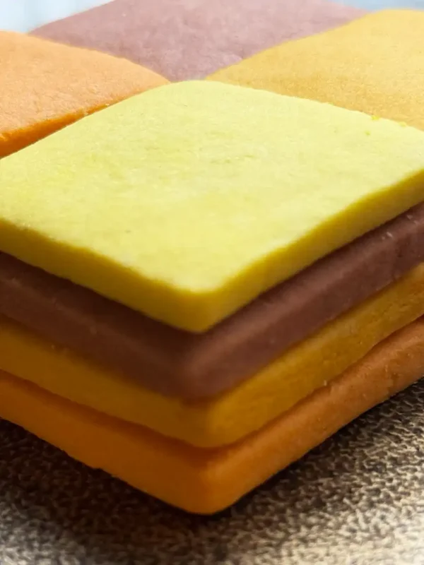 A mosaic of handcrafted citrus cookies showing a natural gradient of warm, sunset tones.