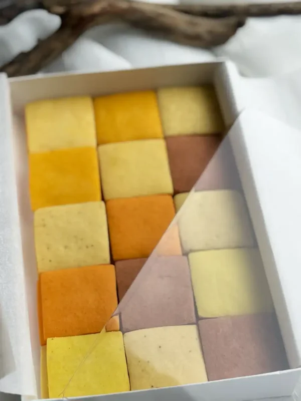 A mosaic of handcrafted citrus cookies showing a natural gradient of warm, sunset tones.